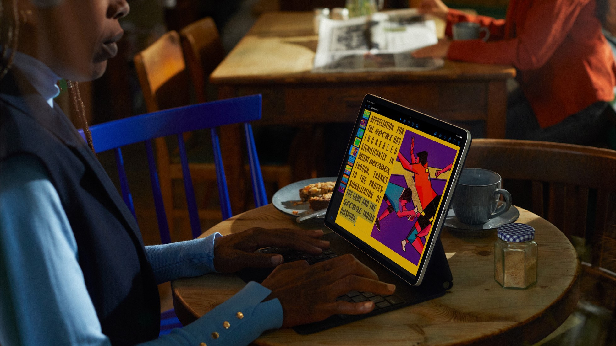 Woman using iPad Pro in coffee shop with keyboard