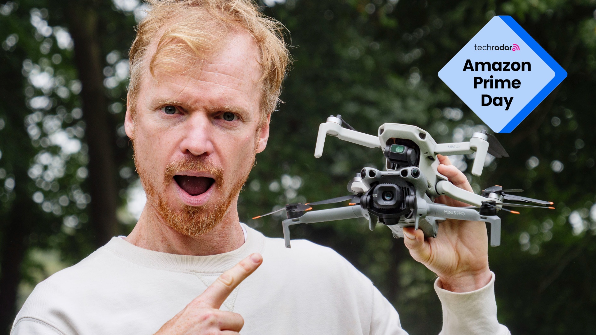 Man holding DJI Mini 4K and DJI Mini 5 Pro drones and comically pointing to them in awe