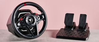 Thrustmaster T128 on desk with pink background