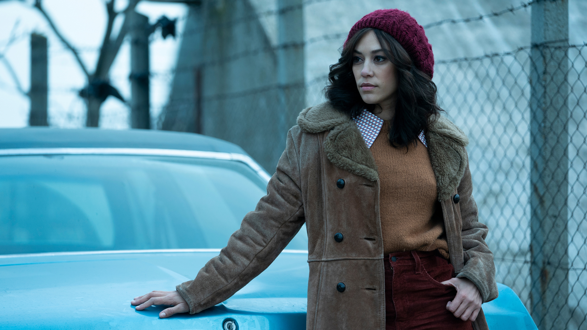 KD rests her hand on a car in The Continental TV show