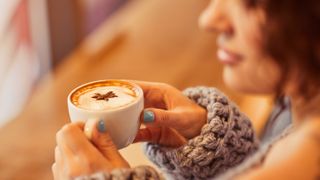 A woman holding a cup of coffee