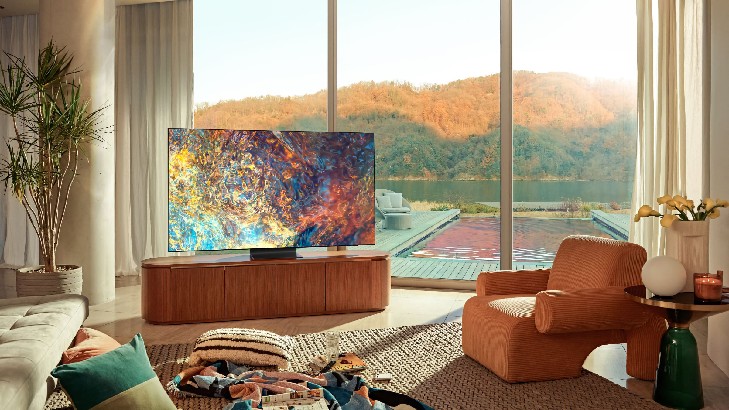 One of Samsung's Mini-LED TVs in a bright living room with a colourful, abstract image displayed on the screen.