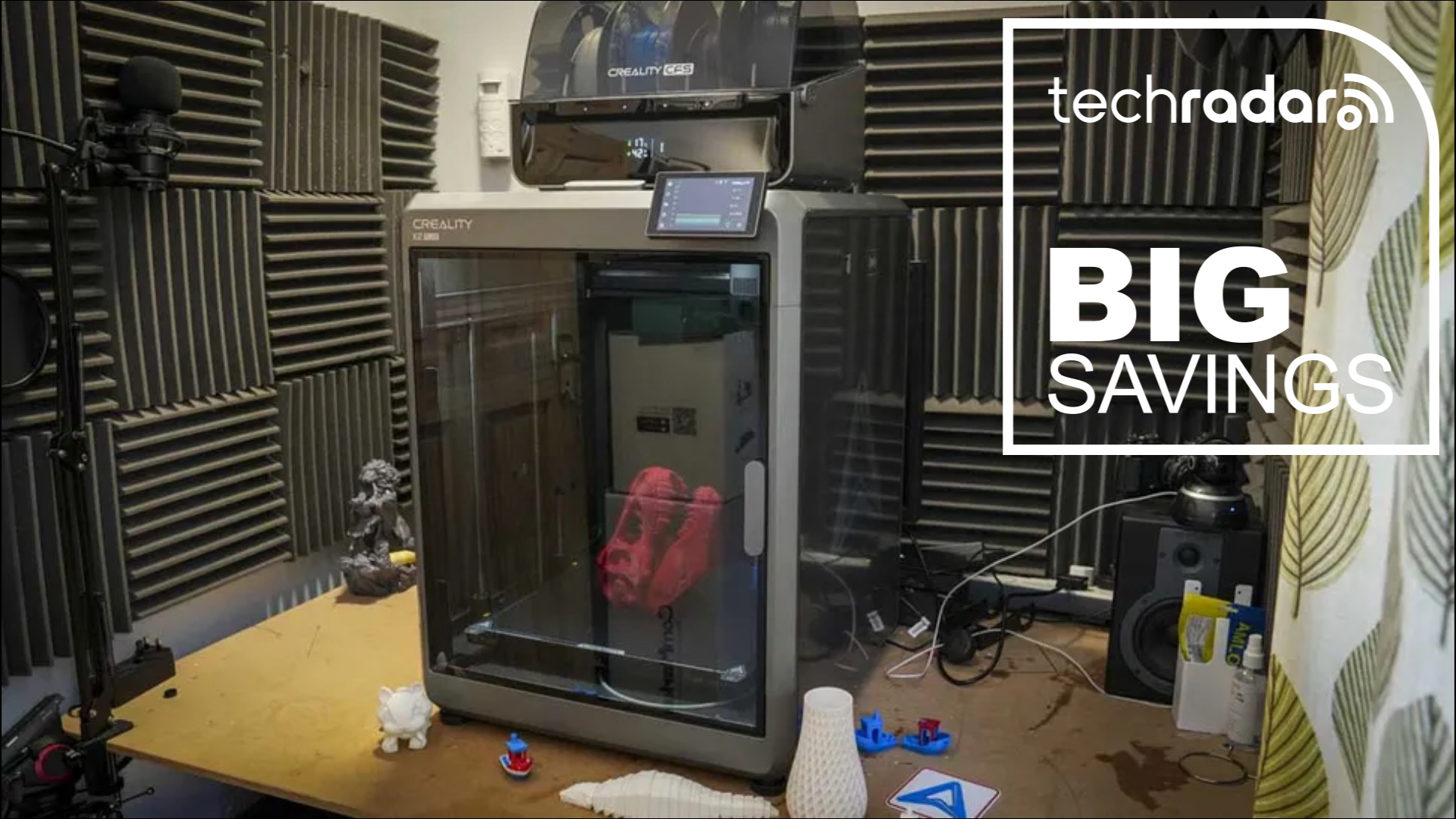 The Creality K2 Plus in our workshop during testing, next to a white TechRadar badge in the upper right corner that reads 'Big Savings' 