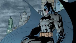 Batman standing on a gargoyle as he overlooks Gotham City
