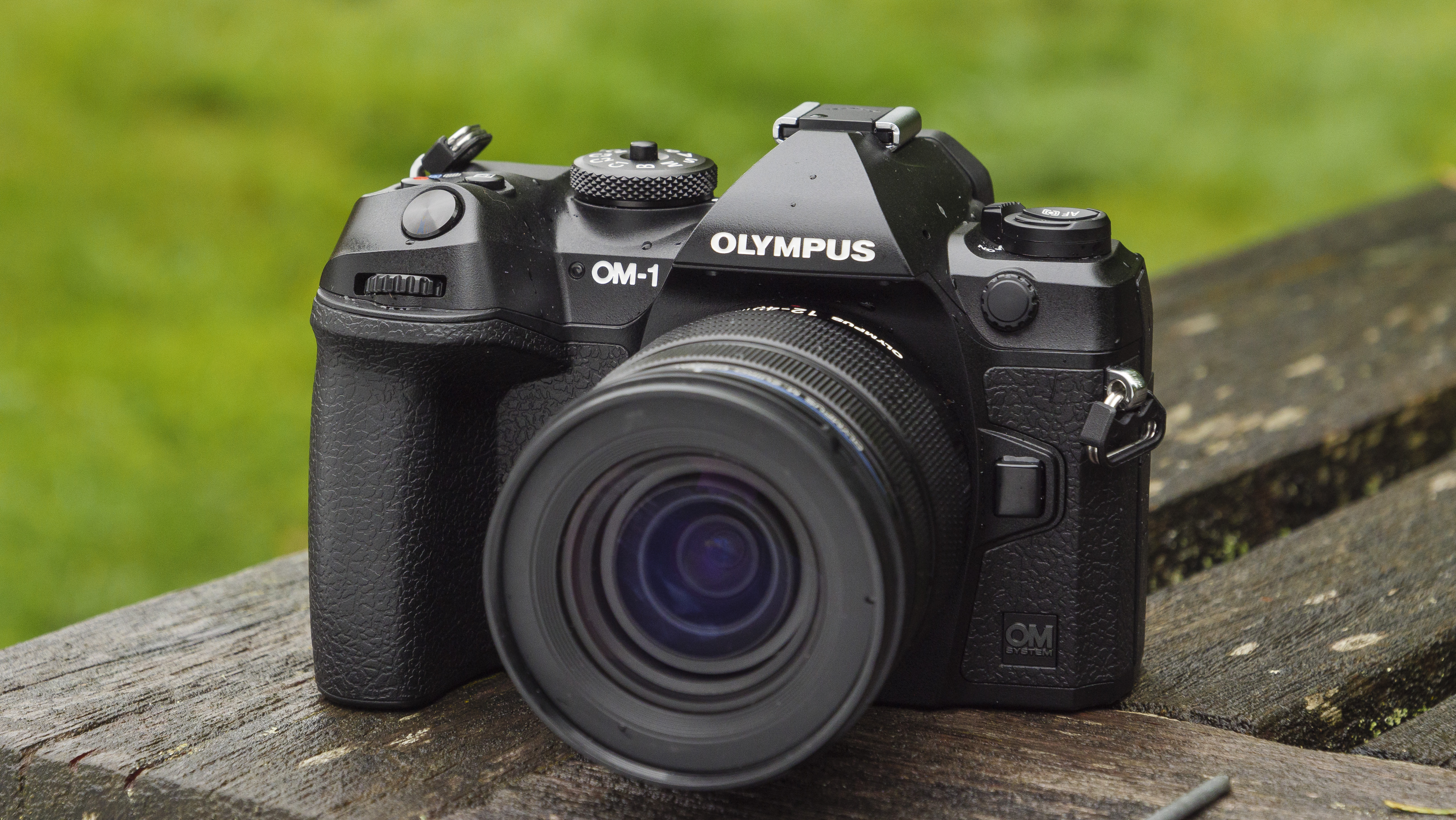 The OM System OM-1 camera on a wooden table