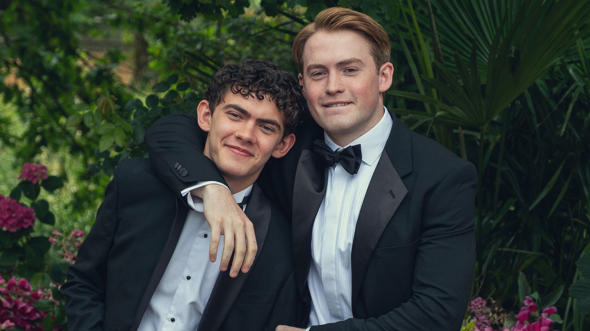 Nick and Charlie wear tuxedos and pose for a photo