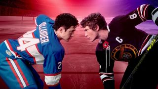 Hudson Williams as Shane Hollander and Connor Storrie as Ilya Rozanov facing off in their hockey gear in a promotional image for Heated Rivalry.