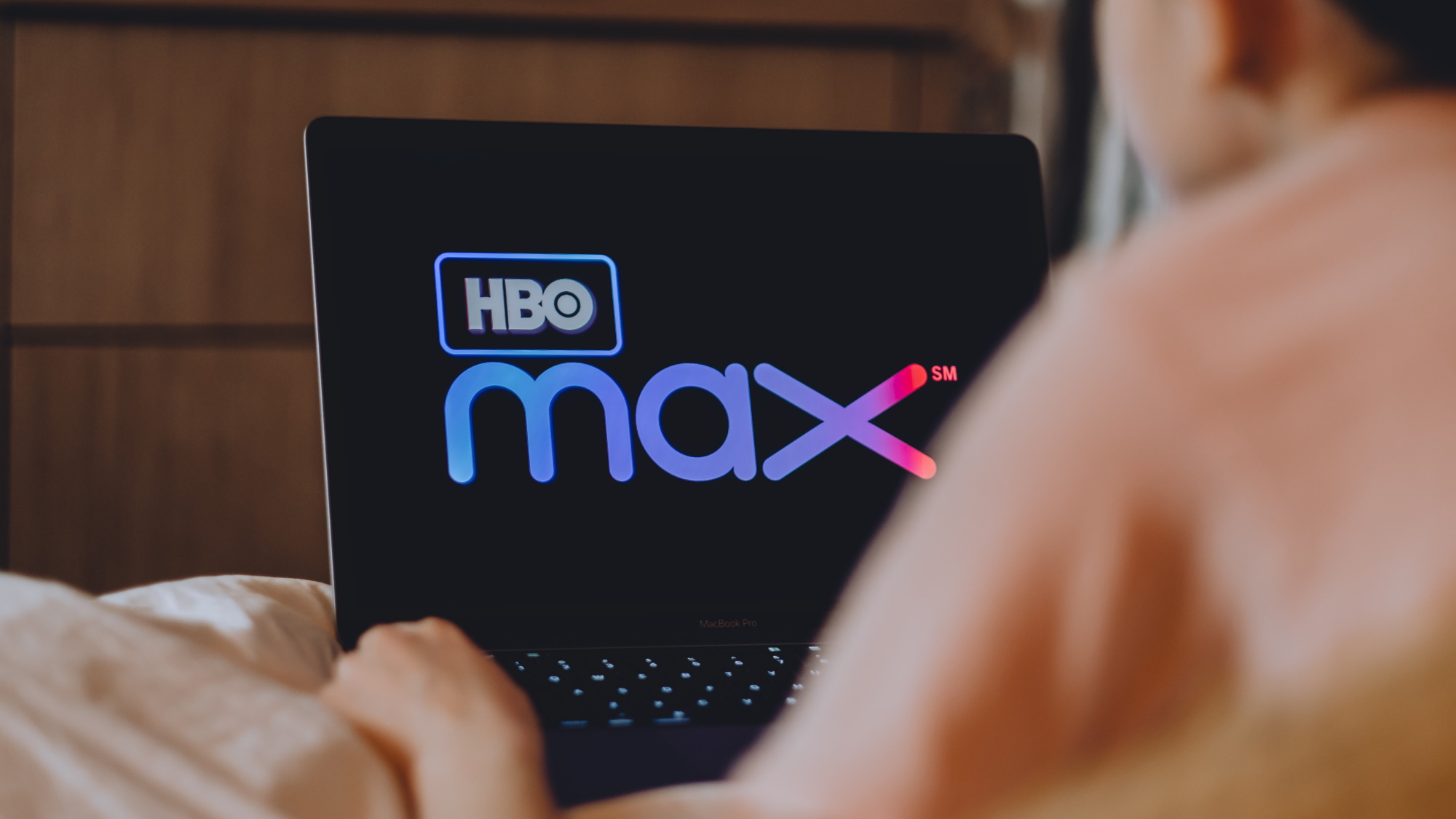 Person on laptop with HBO Max logo on the screen