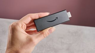 A woman's hand holds the Amazon Fire TV Stick HD.