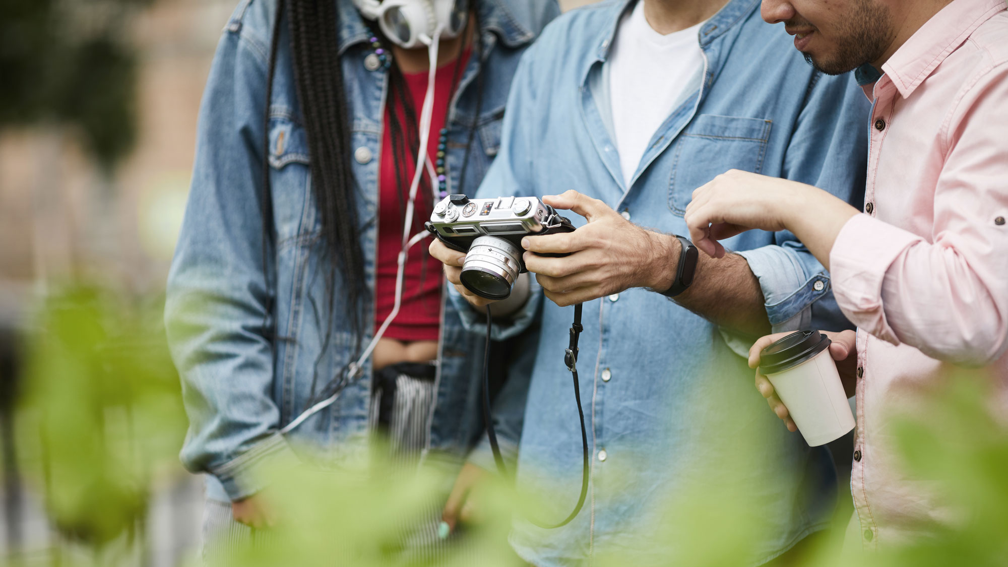 A group of friends look at a camera outdoors during the day