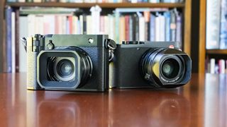 Fujifilm GFX100 RF alongside Leica Q3 on a wooden table