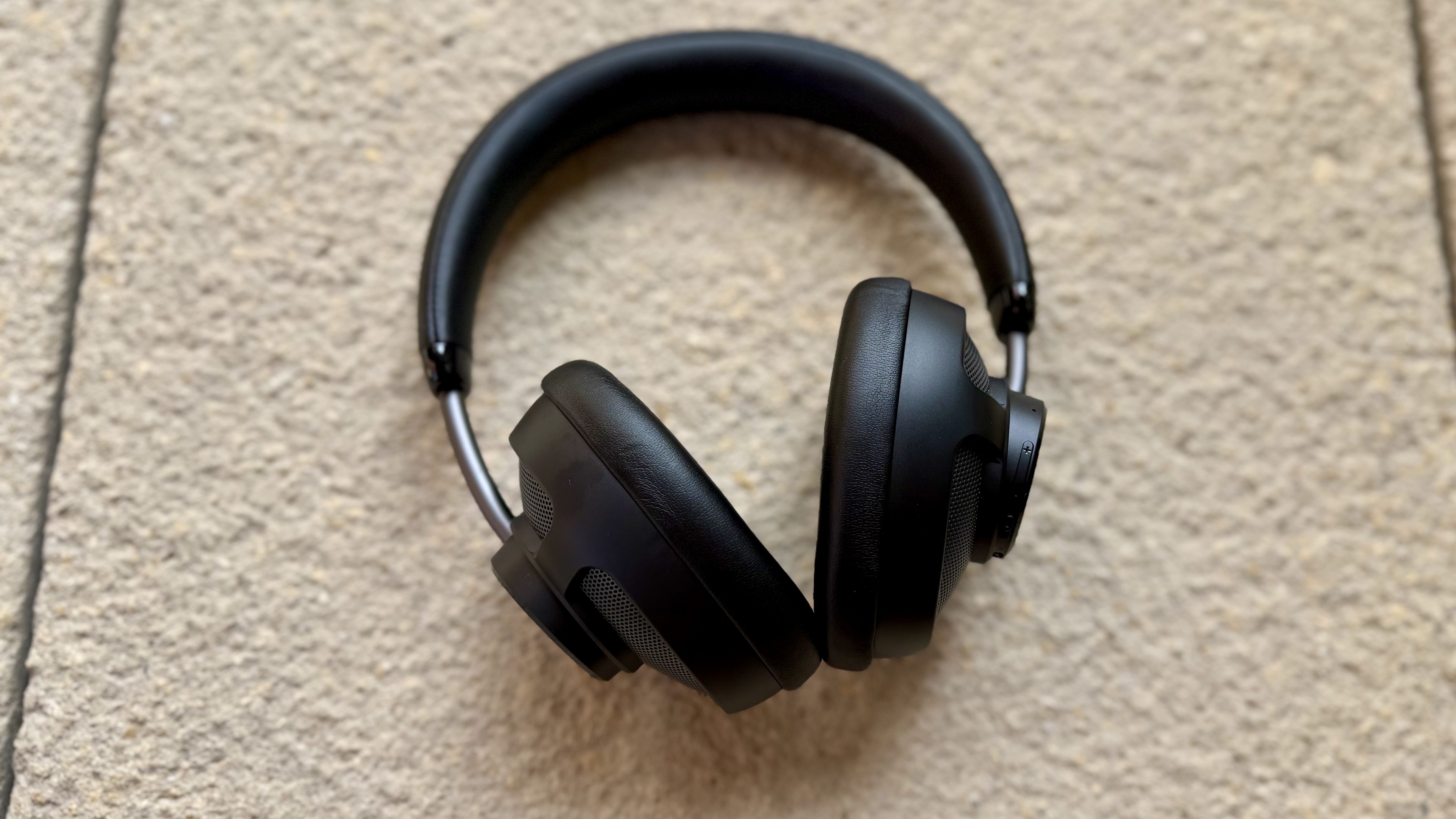 The jlab jbuds open headphones on a stone surface