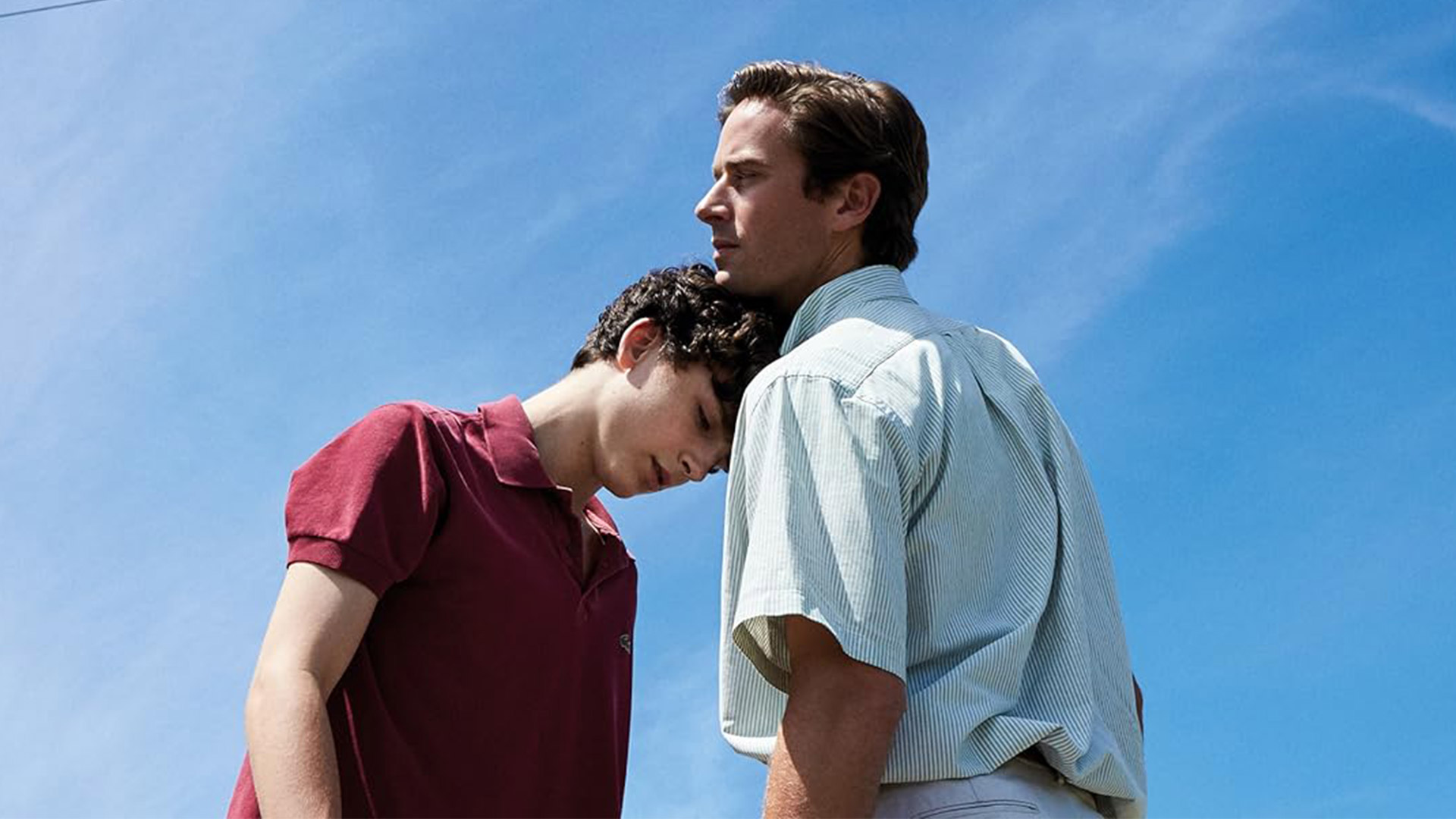 Timoth&eacute;e Chalamet leans his head on Armie Hammer's shoulder against a blue sky