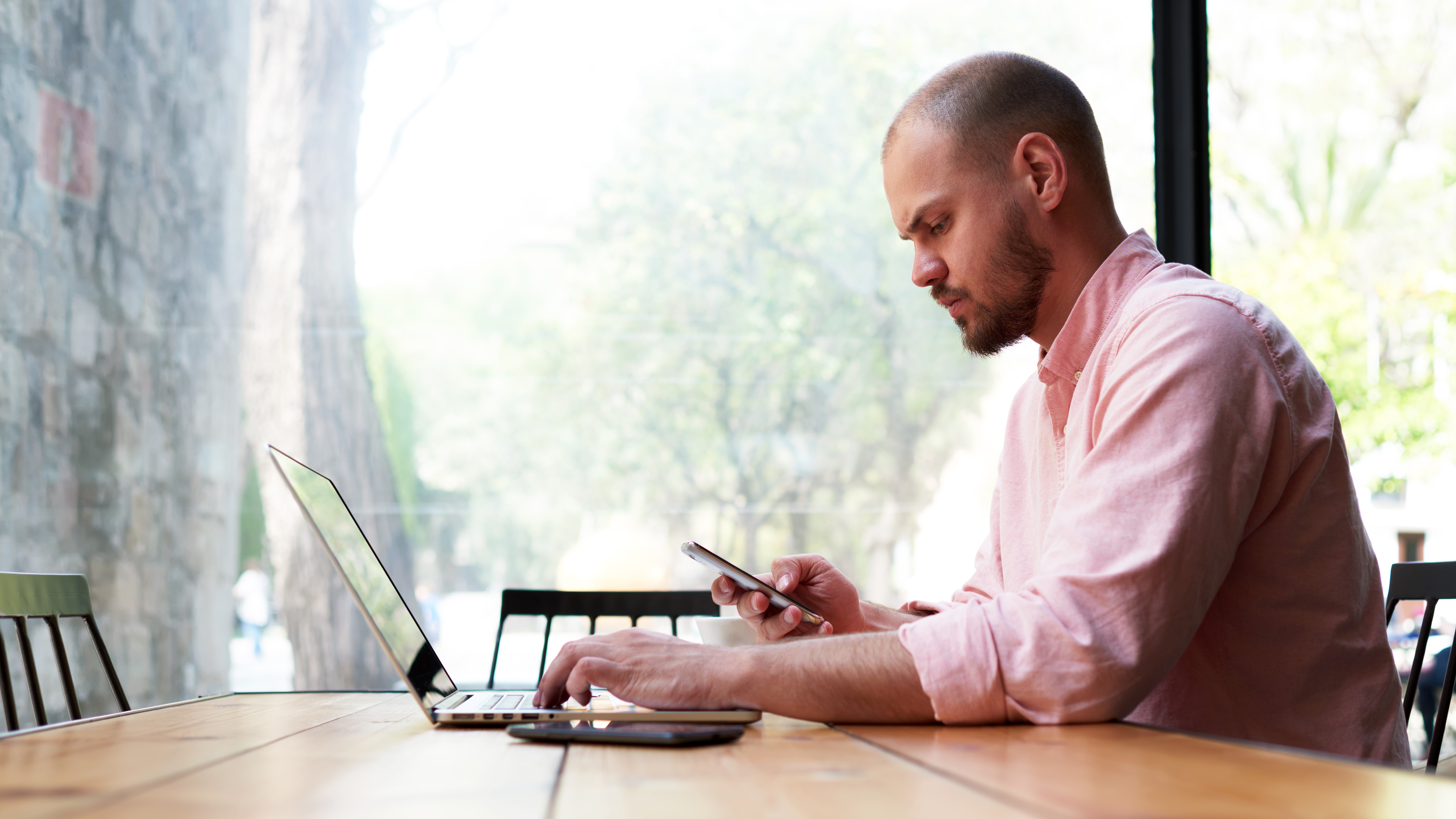Man sitting at a table working on a laptop