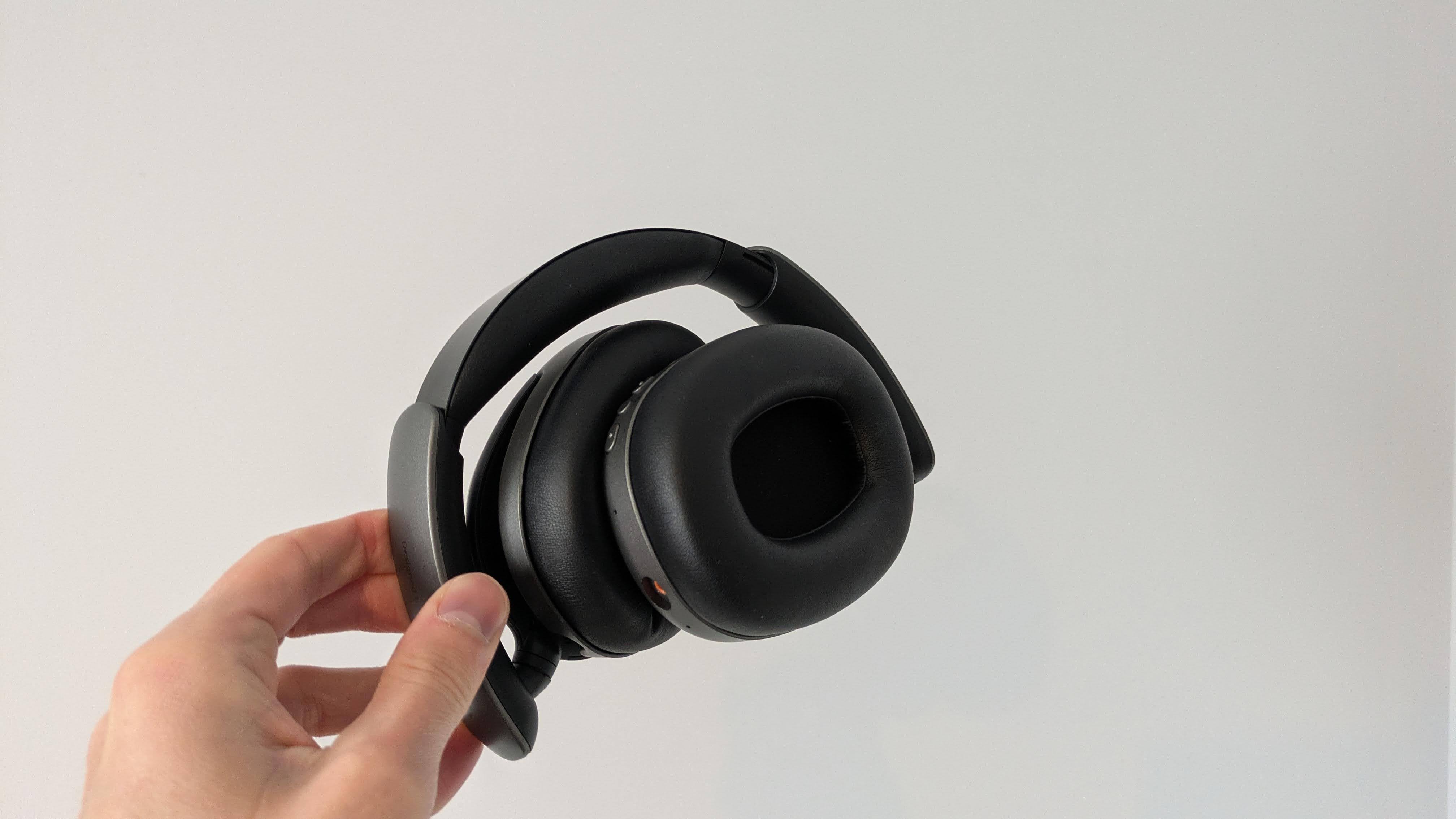 OXS Storm A2 headset folded up with hand holding it, against a white background
