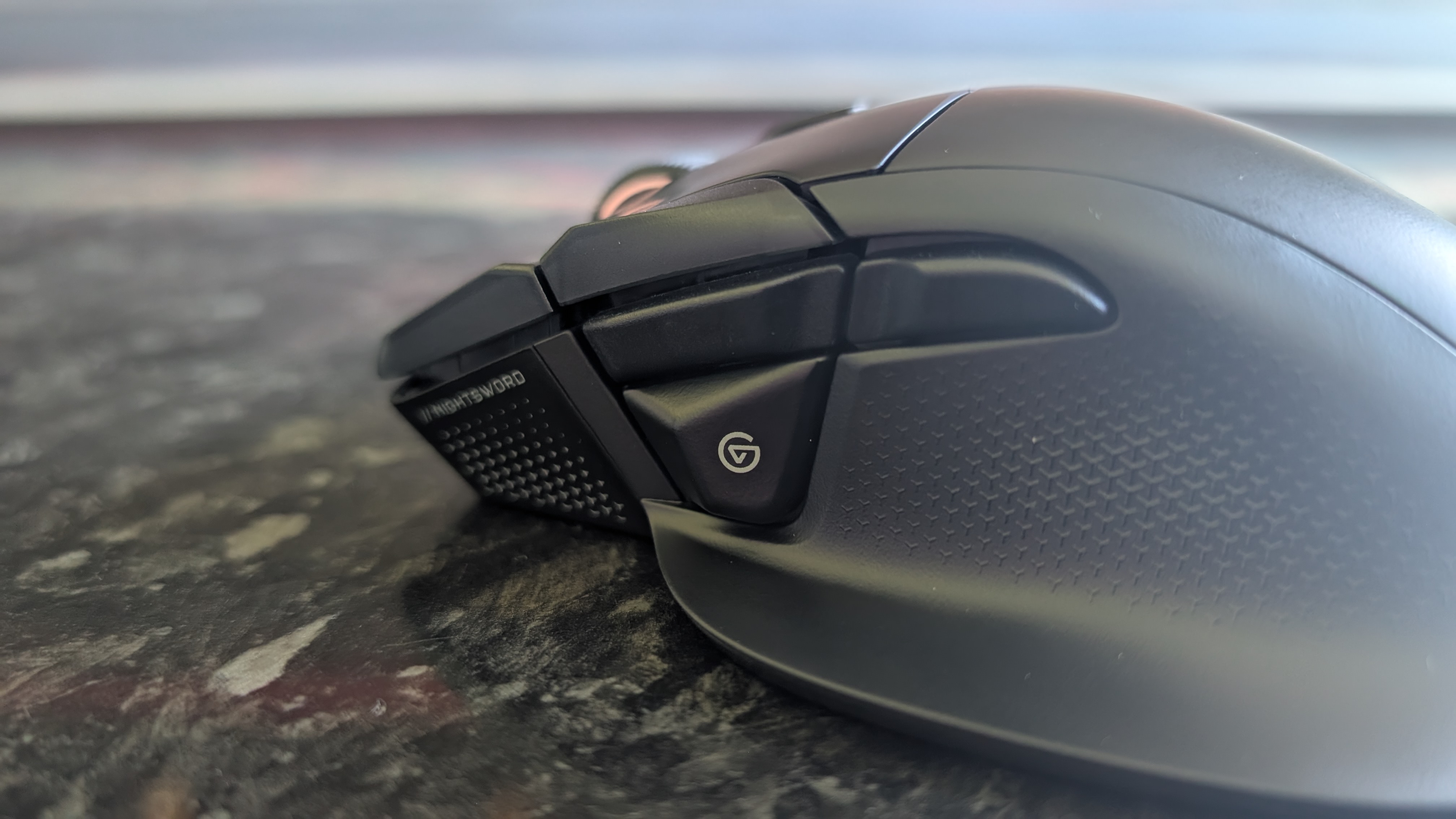 The Corsair Nightsword V2 Wireless gaming mouse pictured on a black marble worktop.