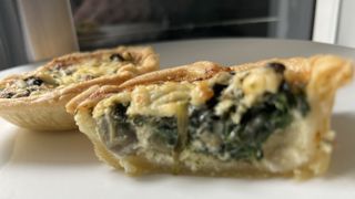air fryer coronation quiche cut in half next to an air fryer