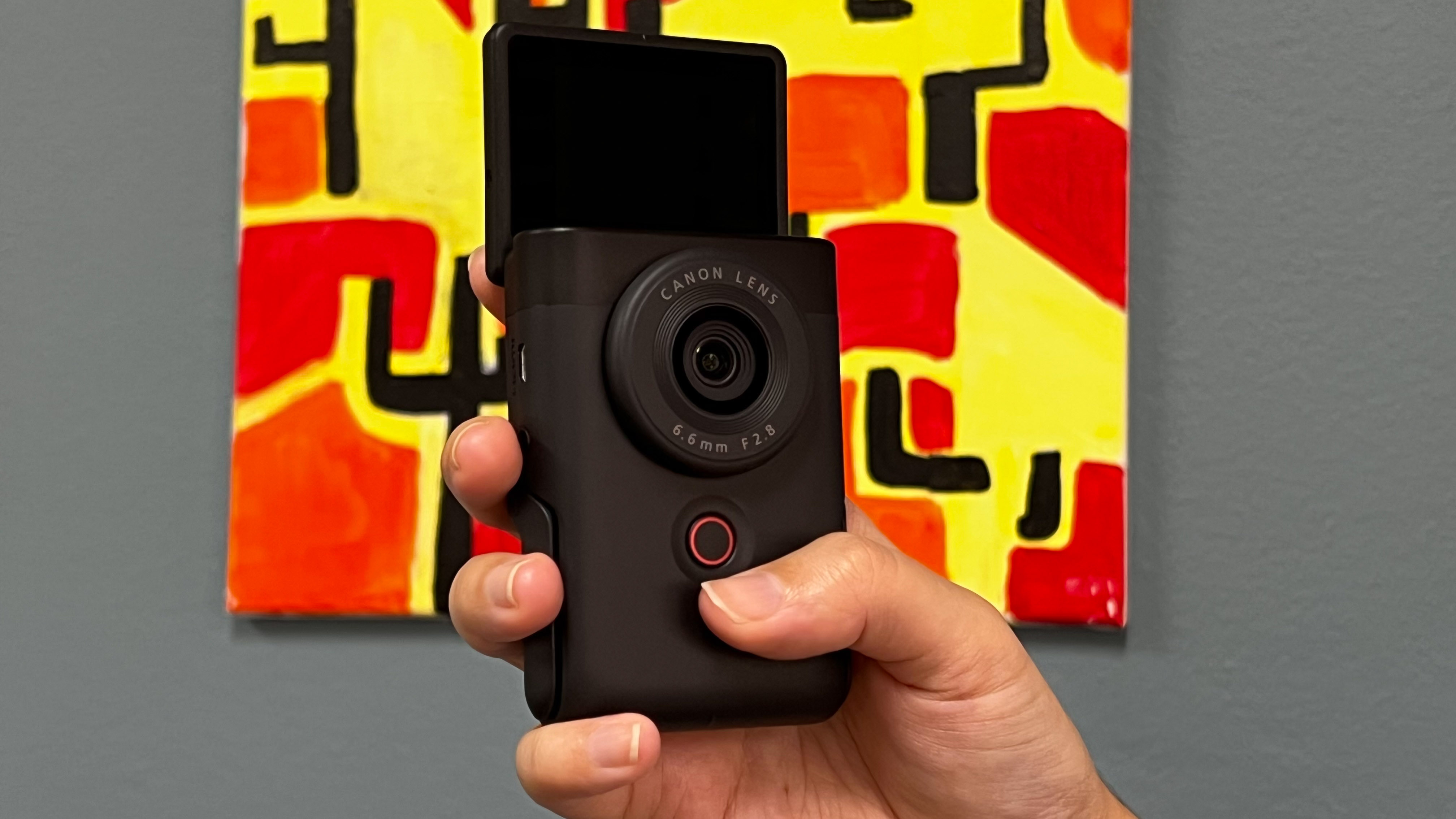 Hand holding the Canon Powershot V10