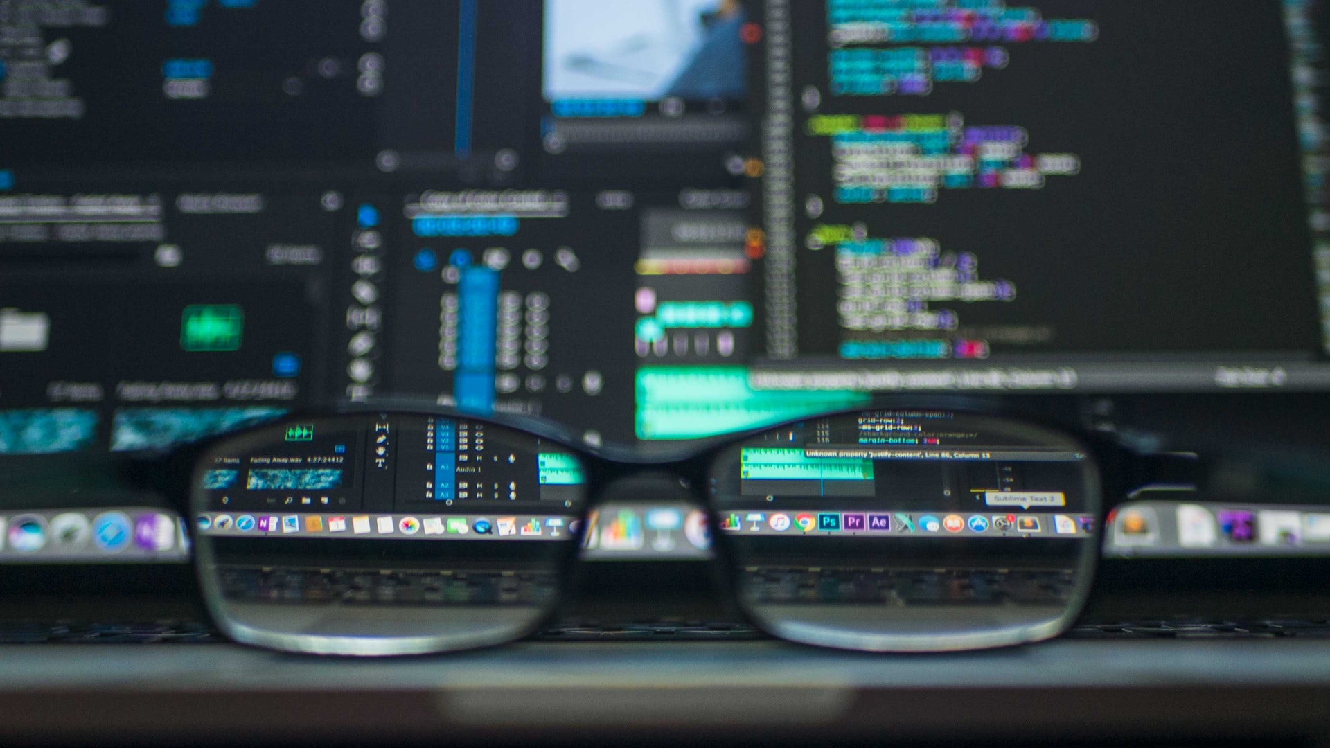 glasses on a keyboard in front of coding