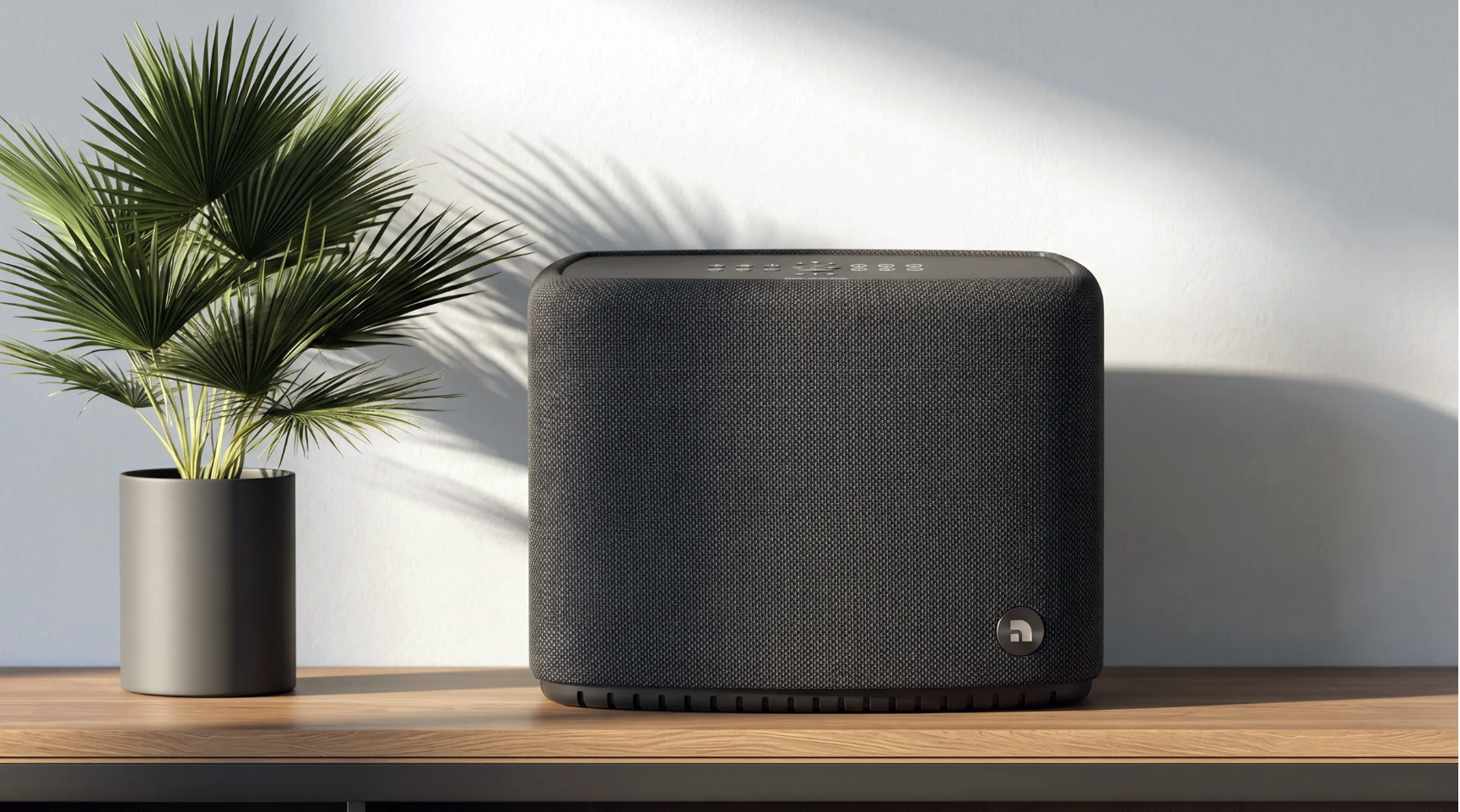 Audio Pro's A15 W speaker on a wooden table, with a house-plant in the background