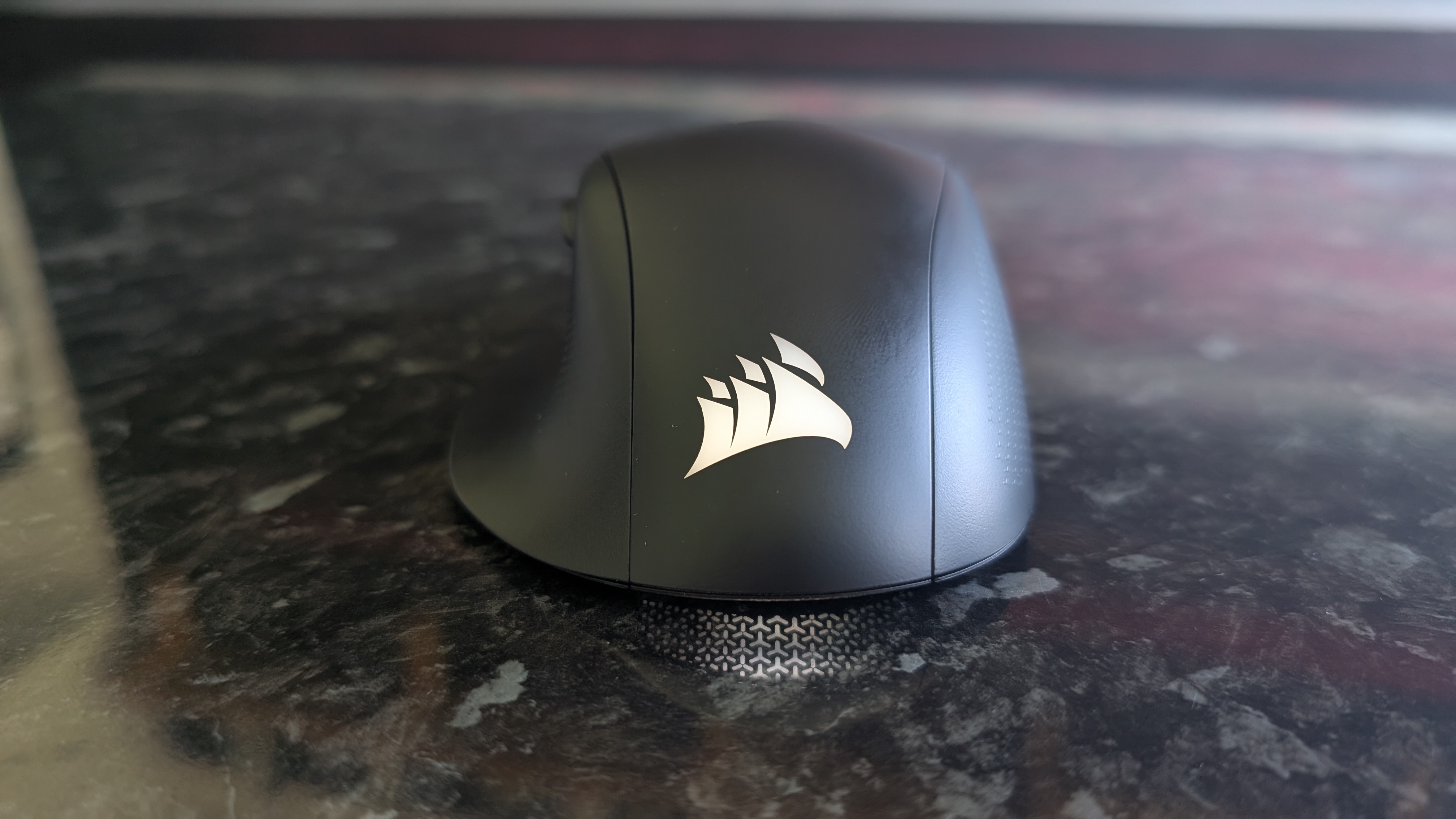 The Corsair Nightsword V2 Wireless gaming mouse pictured on a black marble worktop.