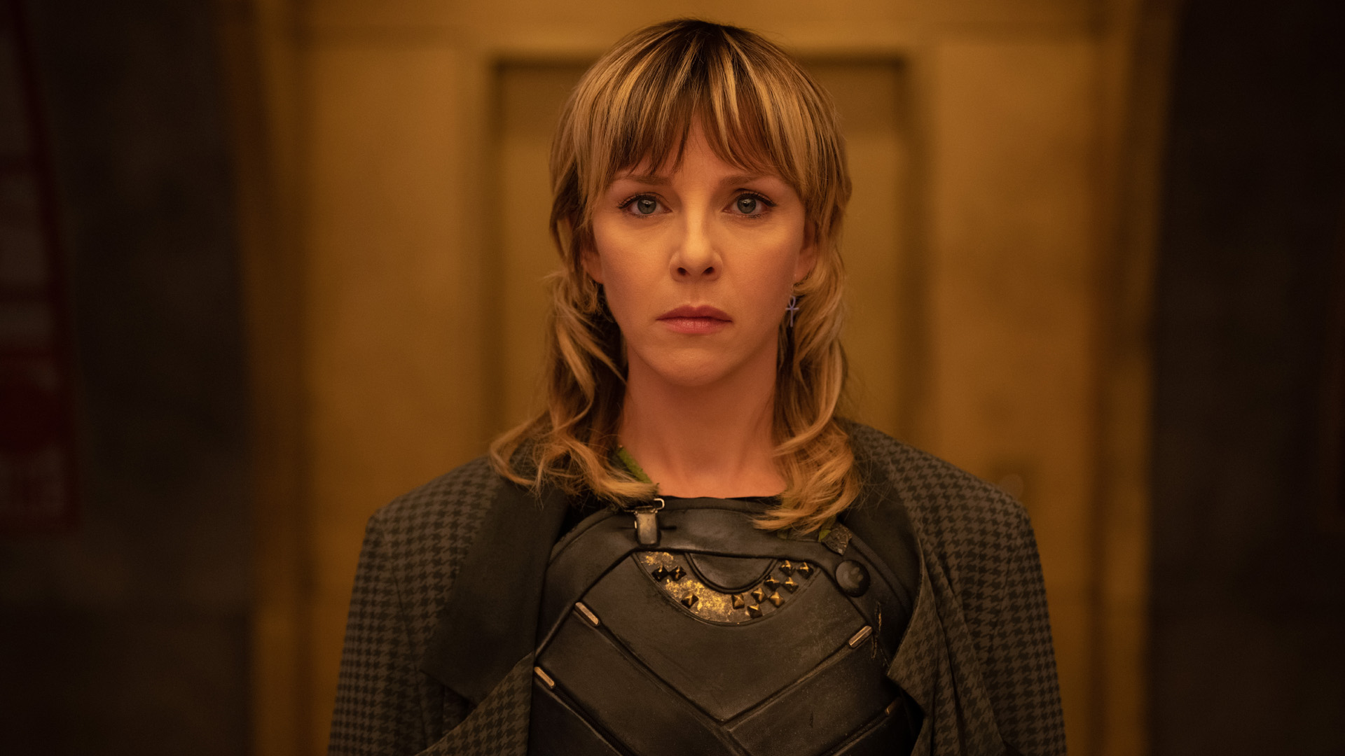 Sylvie stands in an orange lit hallway in Loki season 2