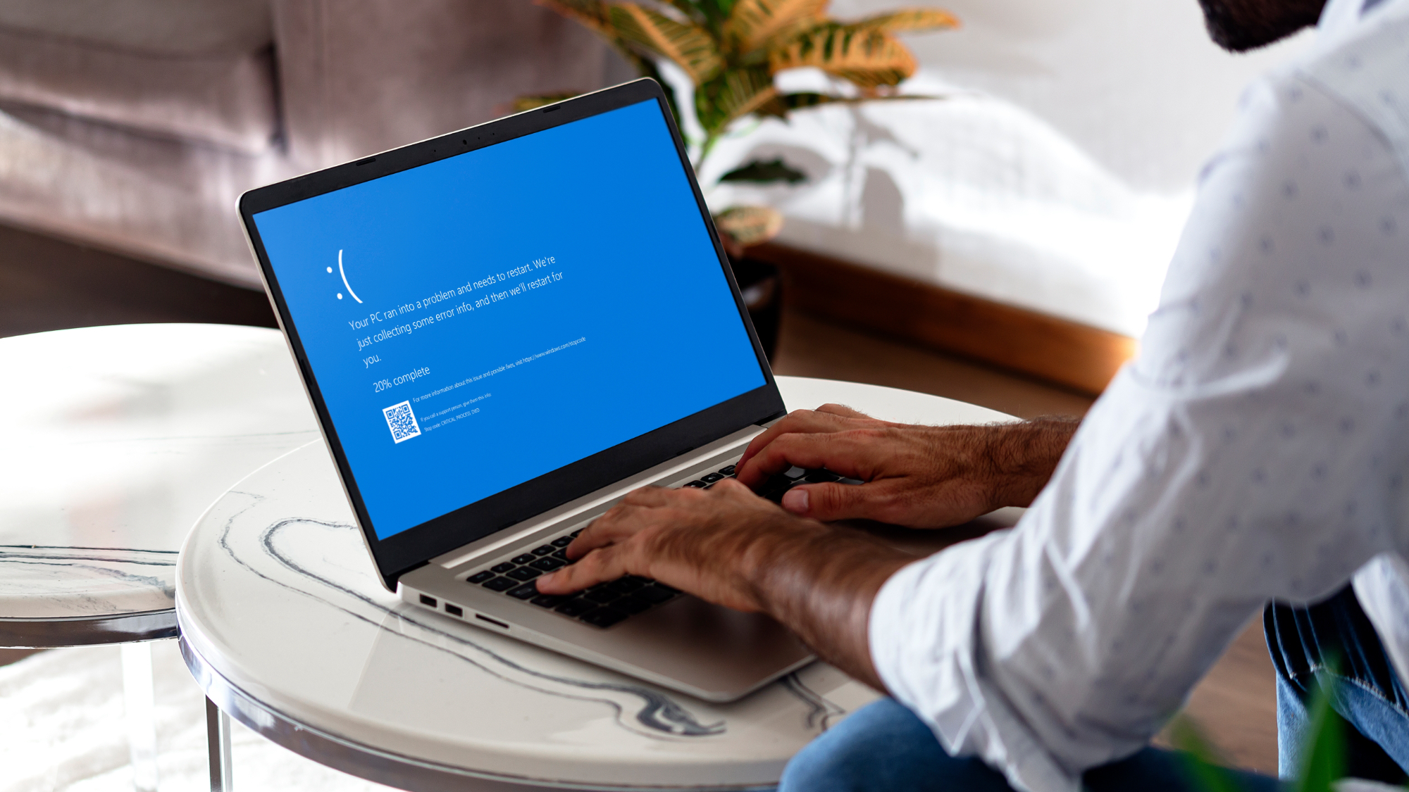 Man with laptop showing Blue screen of death or BSOD on the monitor screen