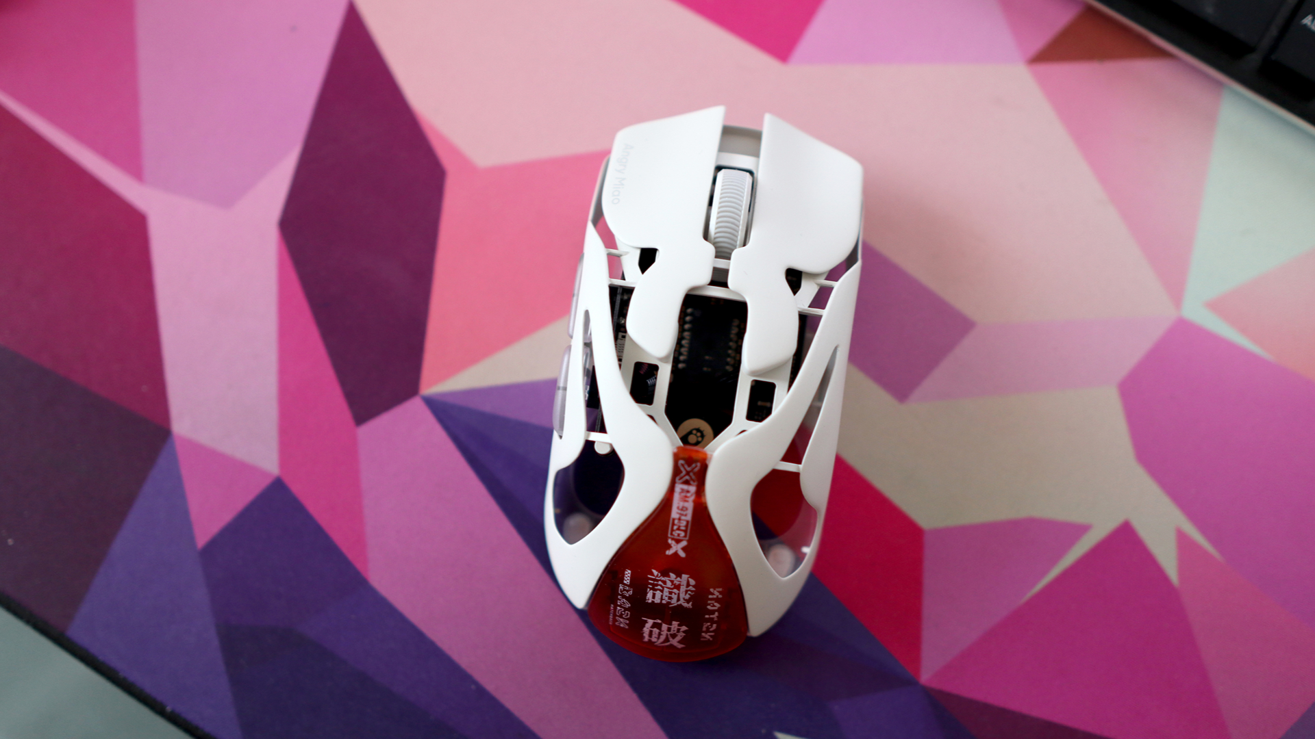 AngryMiao AM Infinity.97 gaming mouse on a colorful desk