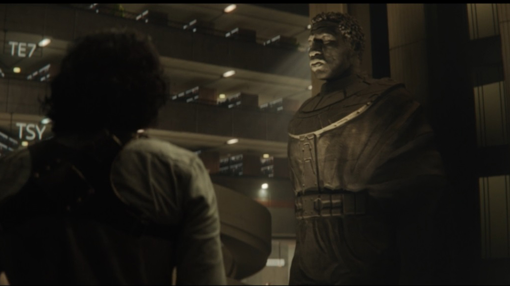 Loki looks on at a statue of Kang the Conqueror in Marvel's Loki episode 6