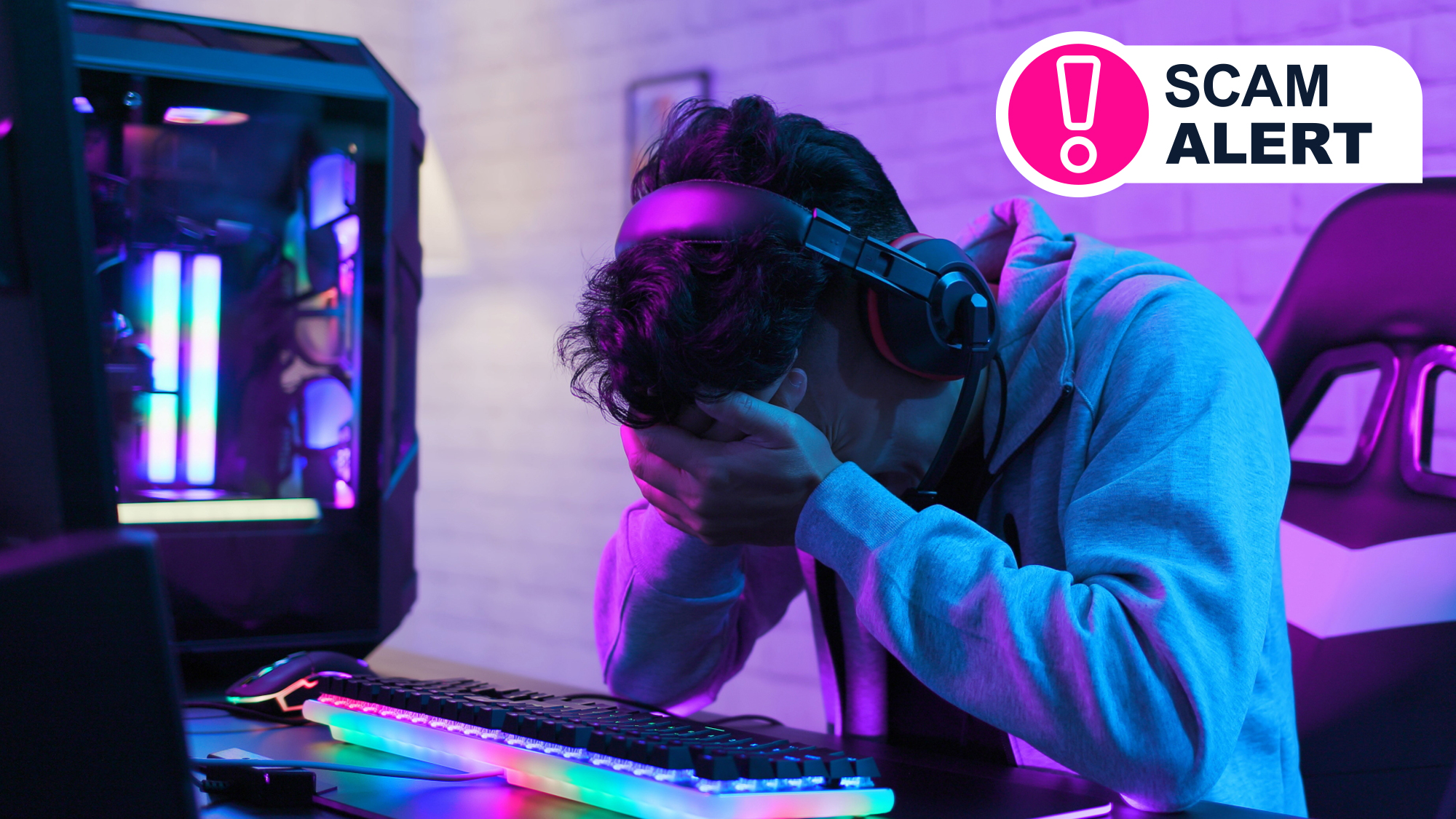 A man sitting in front of a PC with his head in his hands