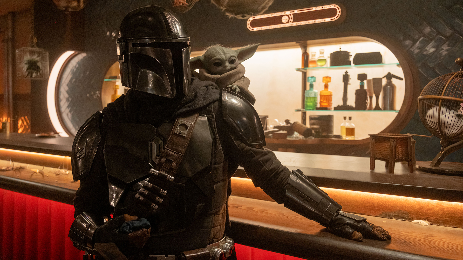 Din Djarin and Baby Yoda standing in a bar in The Mandalorian and Grogu