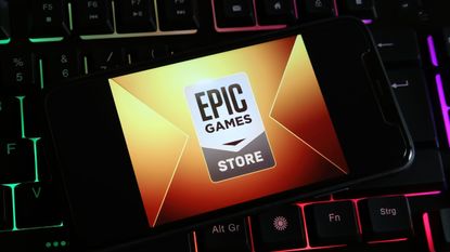 Closeup of smartphone on computer keyboard with logo lettering of Epic games on screen