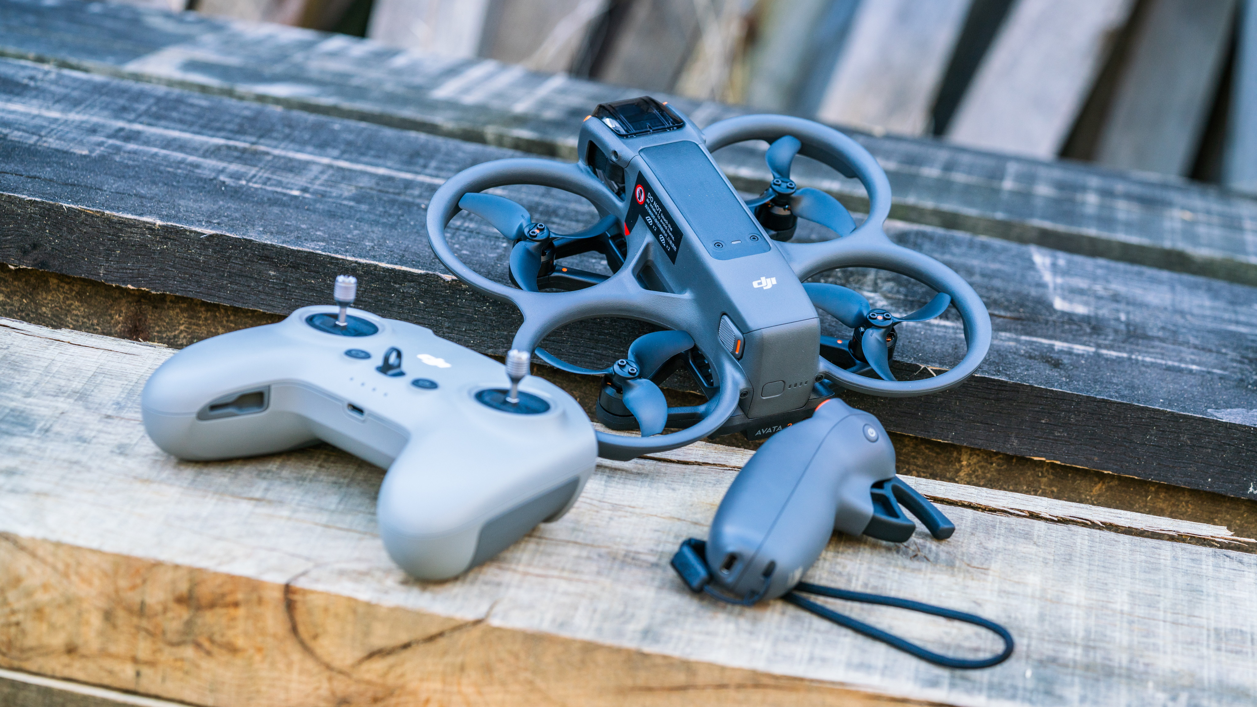 DJI Avata 2 FPV drone with controller and goggles on a wooden bench