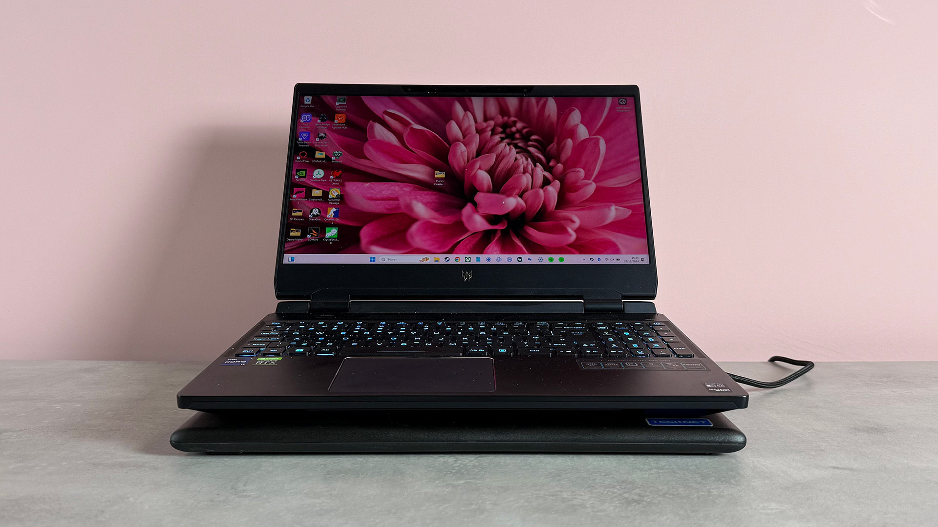 The Tecknet N5 Laptop Cooling Pad featuring a gaming laptop on a pink background.