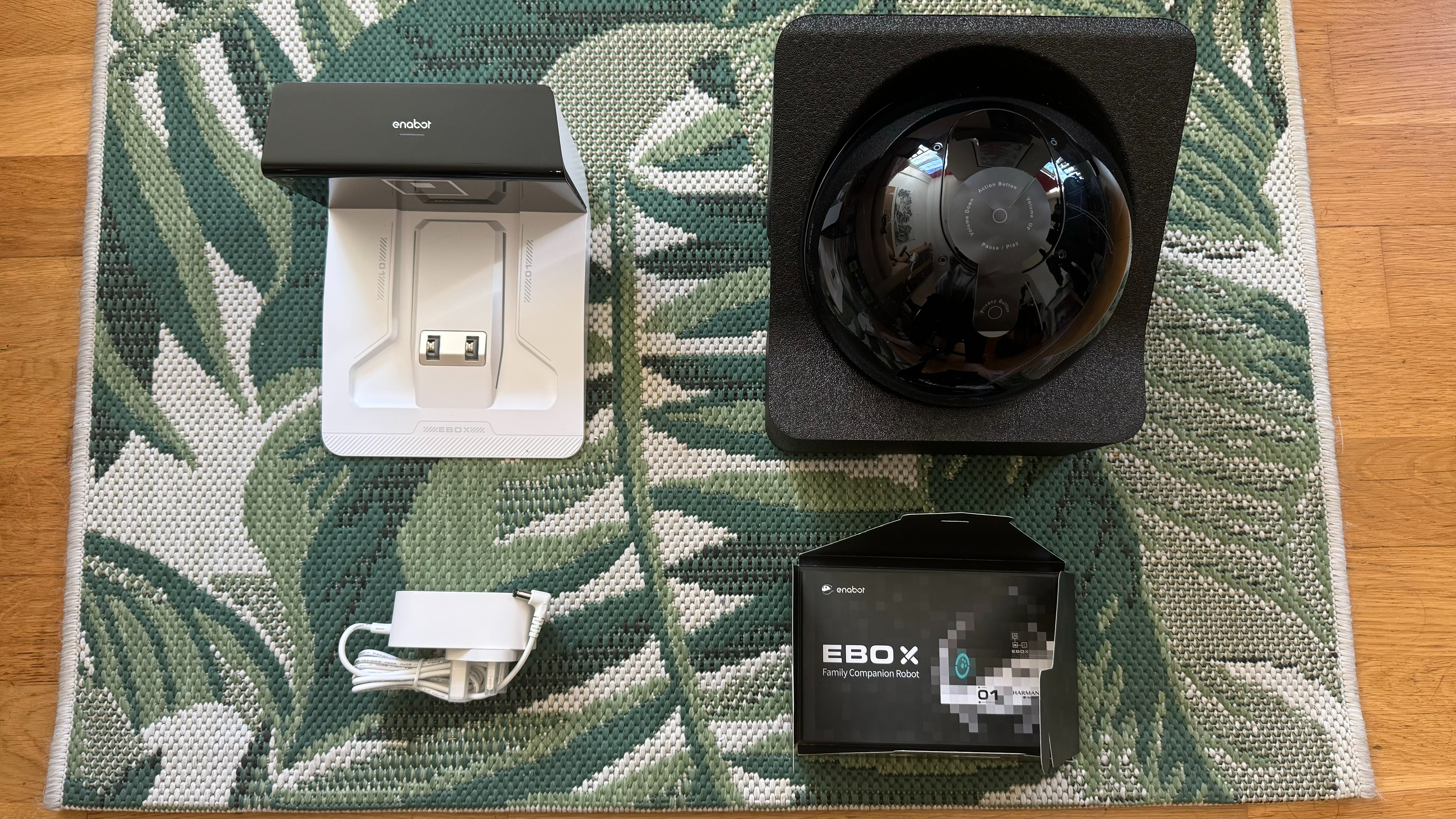 Enabot Ebo X unboxed, with the robot, plug, instruction manual and base all on display