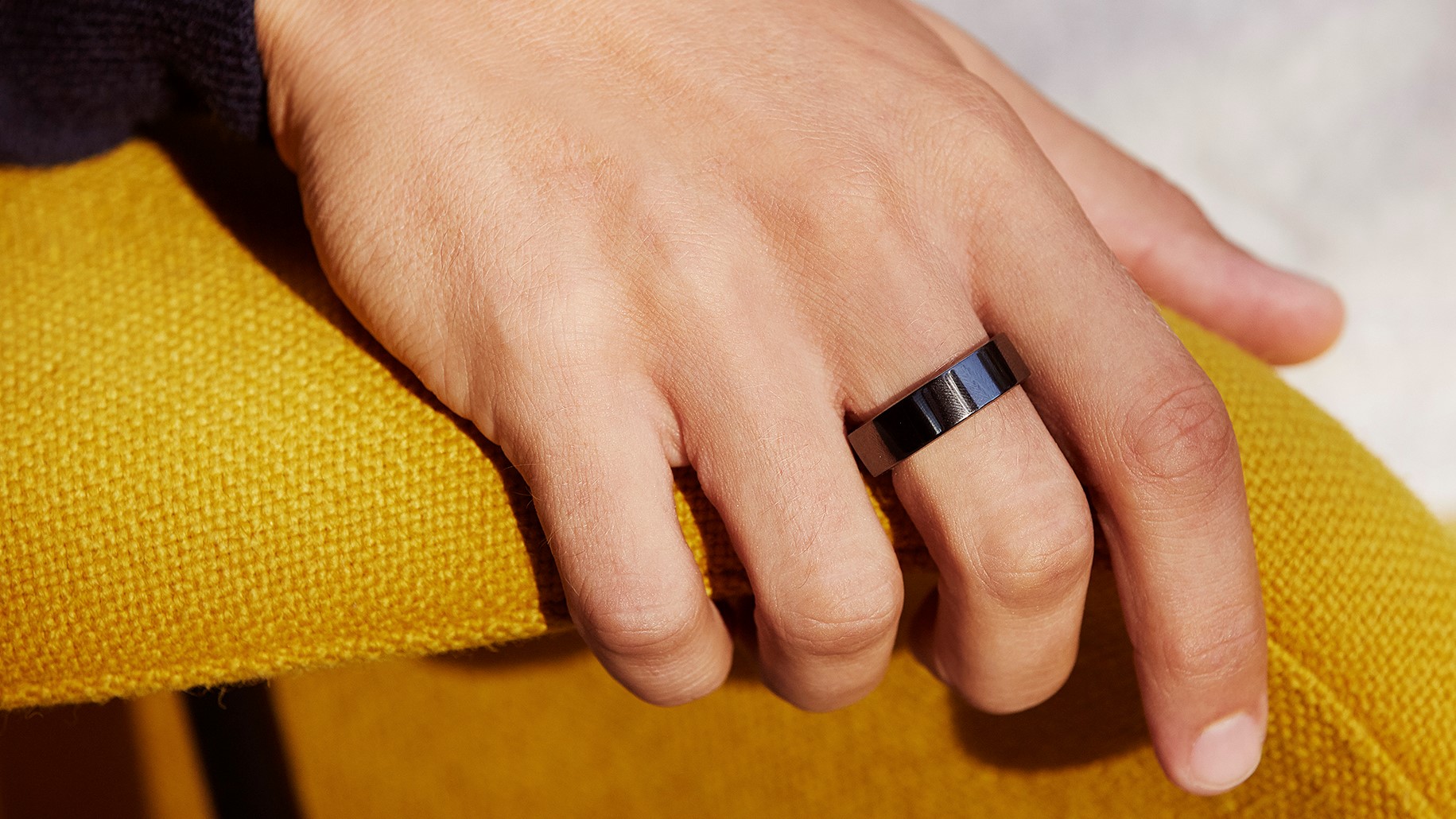 Man's hand wearing black Oura ring