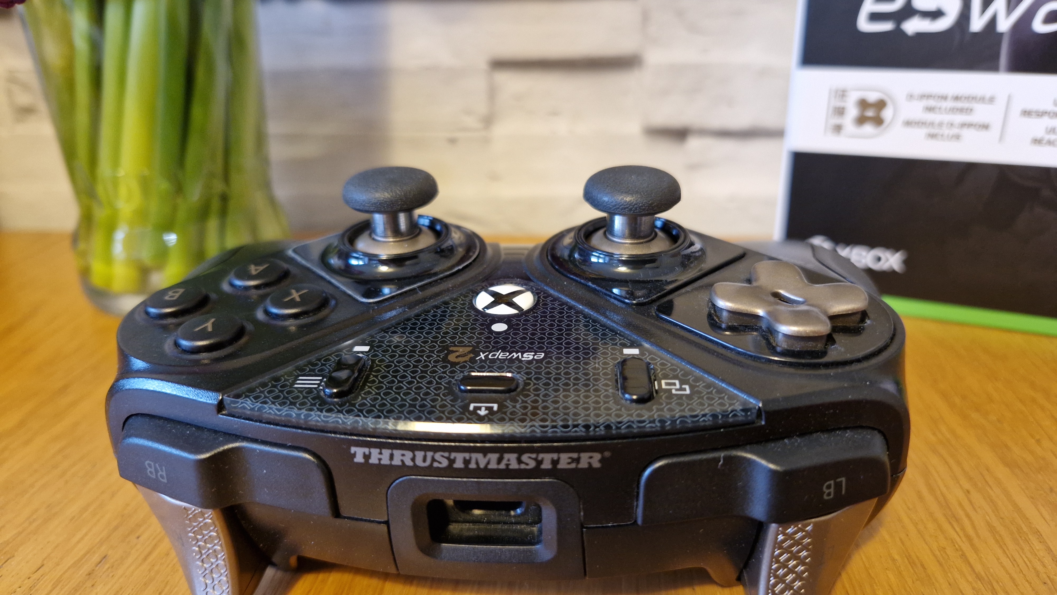 The Thrustmaster eSwap X2 controller on a wooden surface