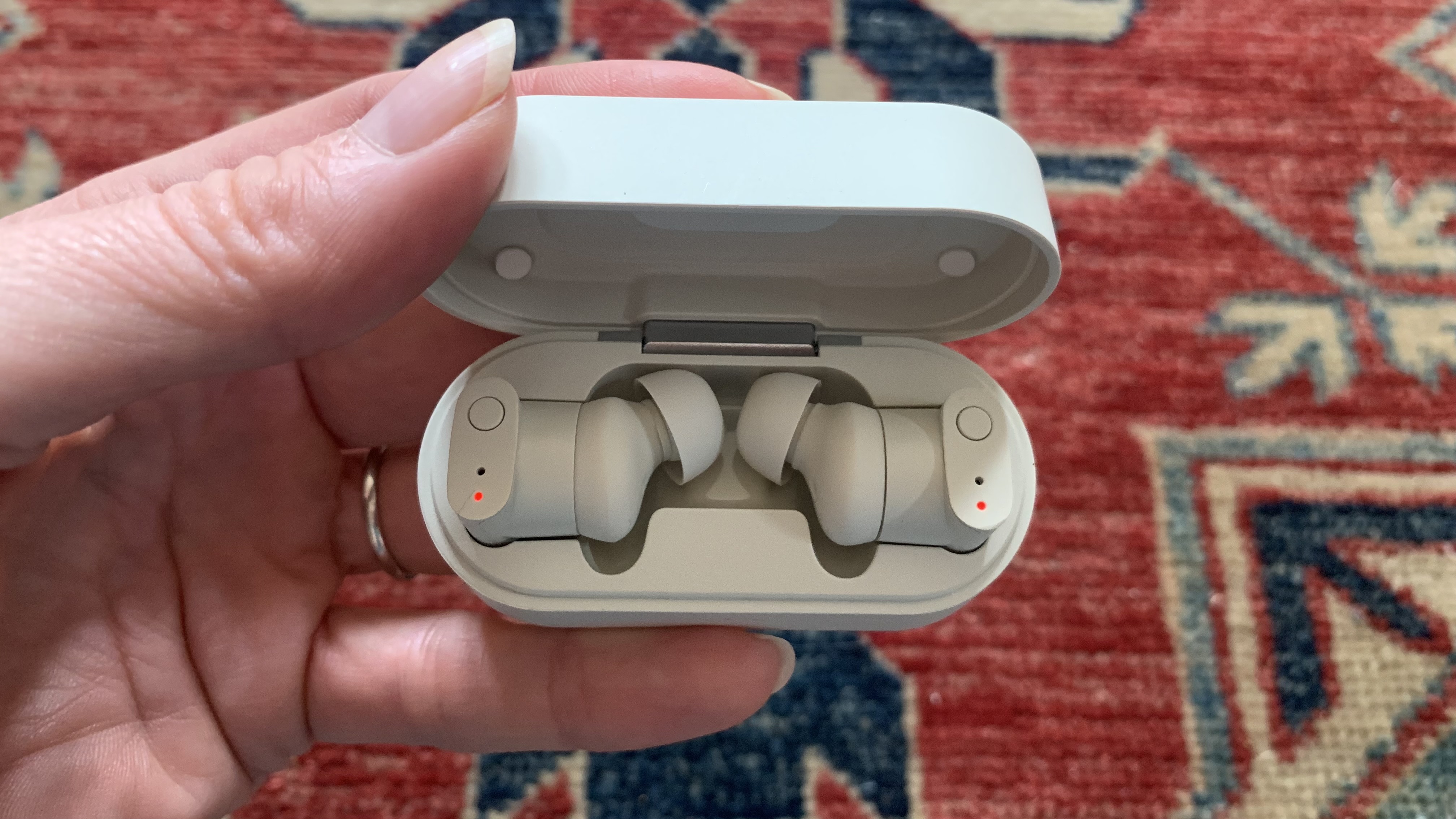 Status Between 3ANC earbuds in their case, on colorful background