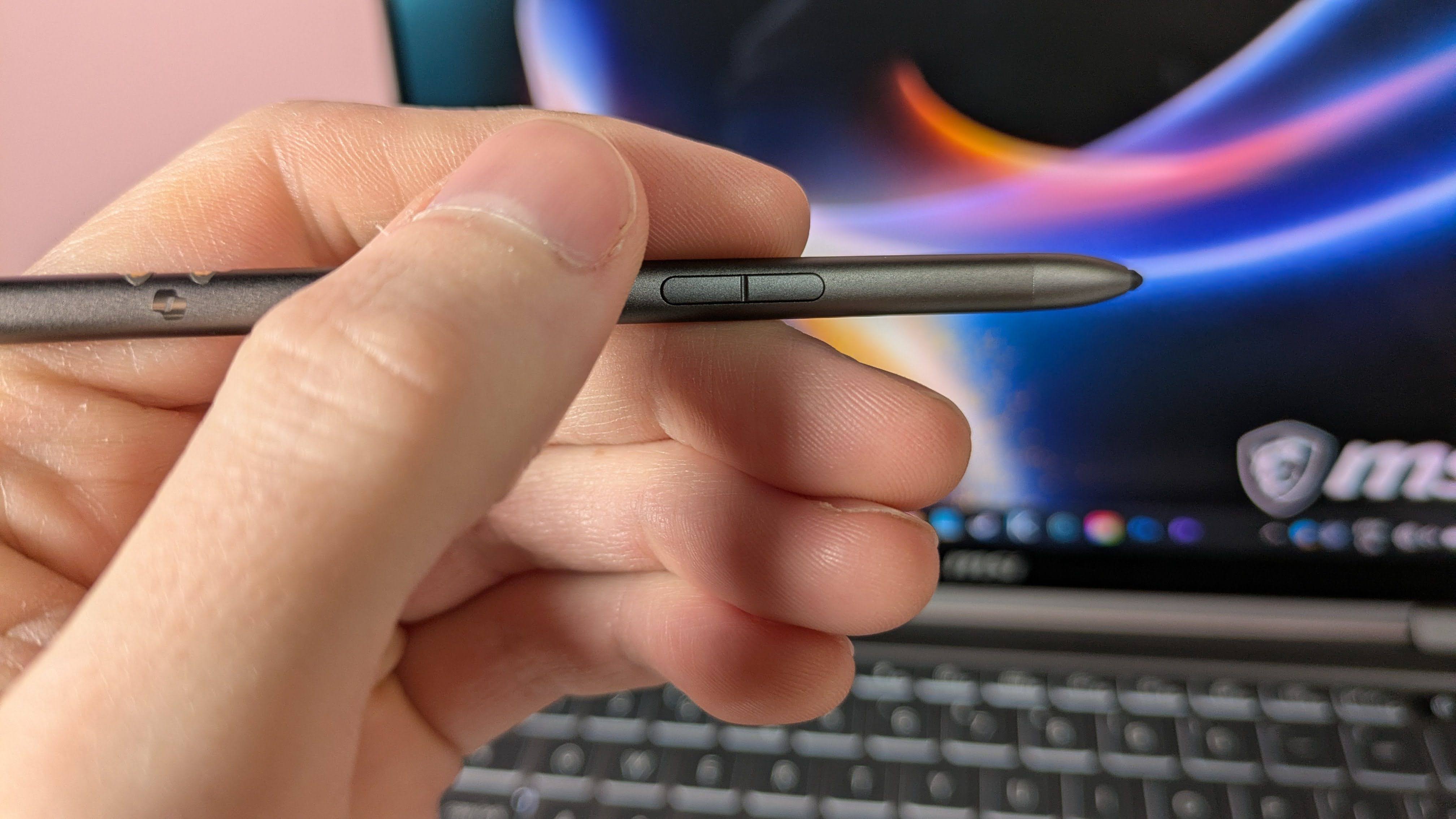Hand holding MSI Nano Pen with MSI Prestige 14 Flip AI+ and pink wall in background