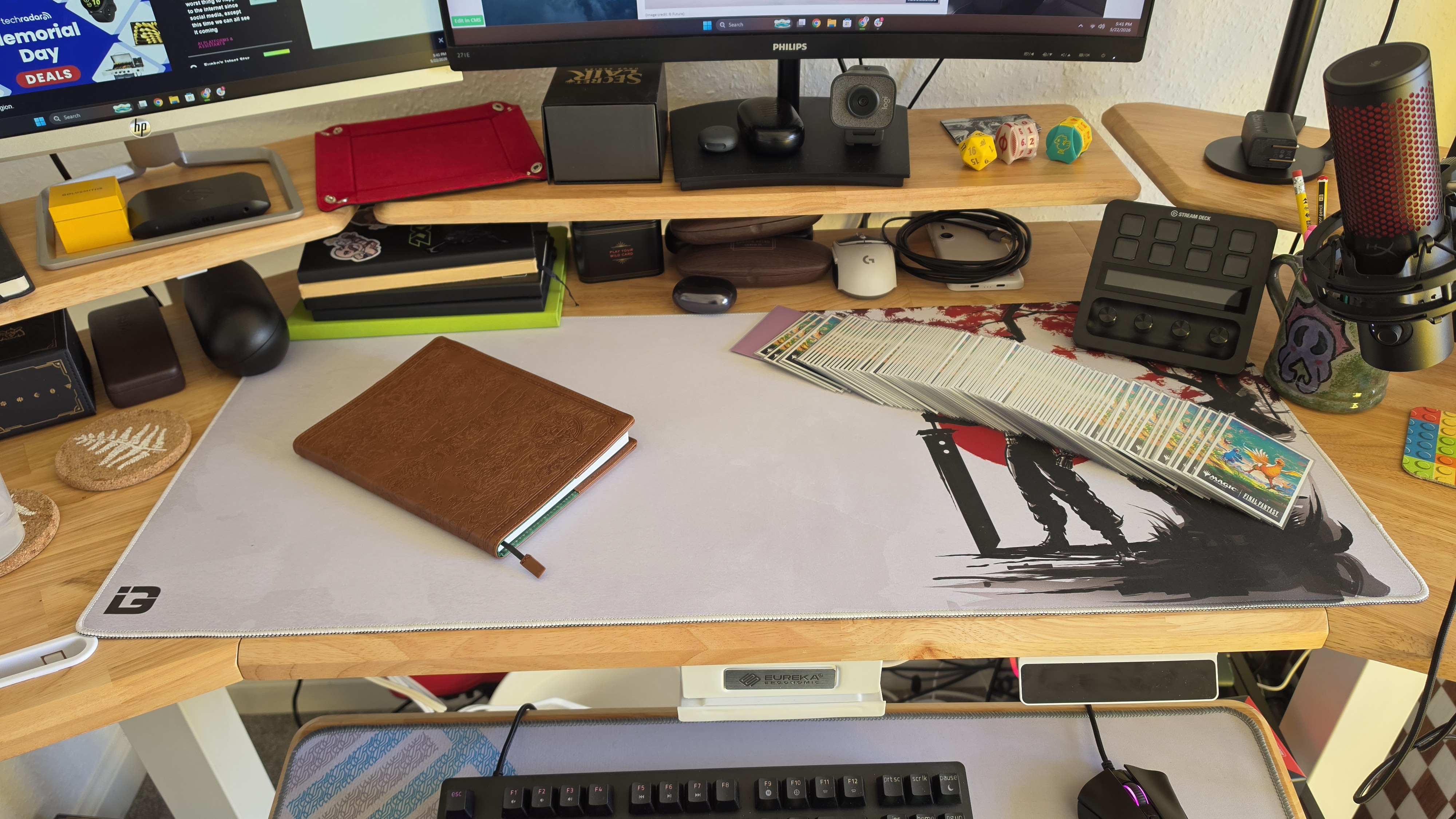 The Eureka Ergonomic Aero Pro's main desk with a notebook and MTG deck