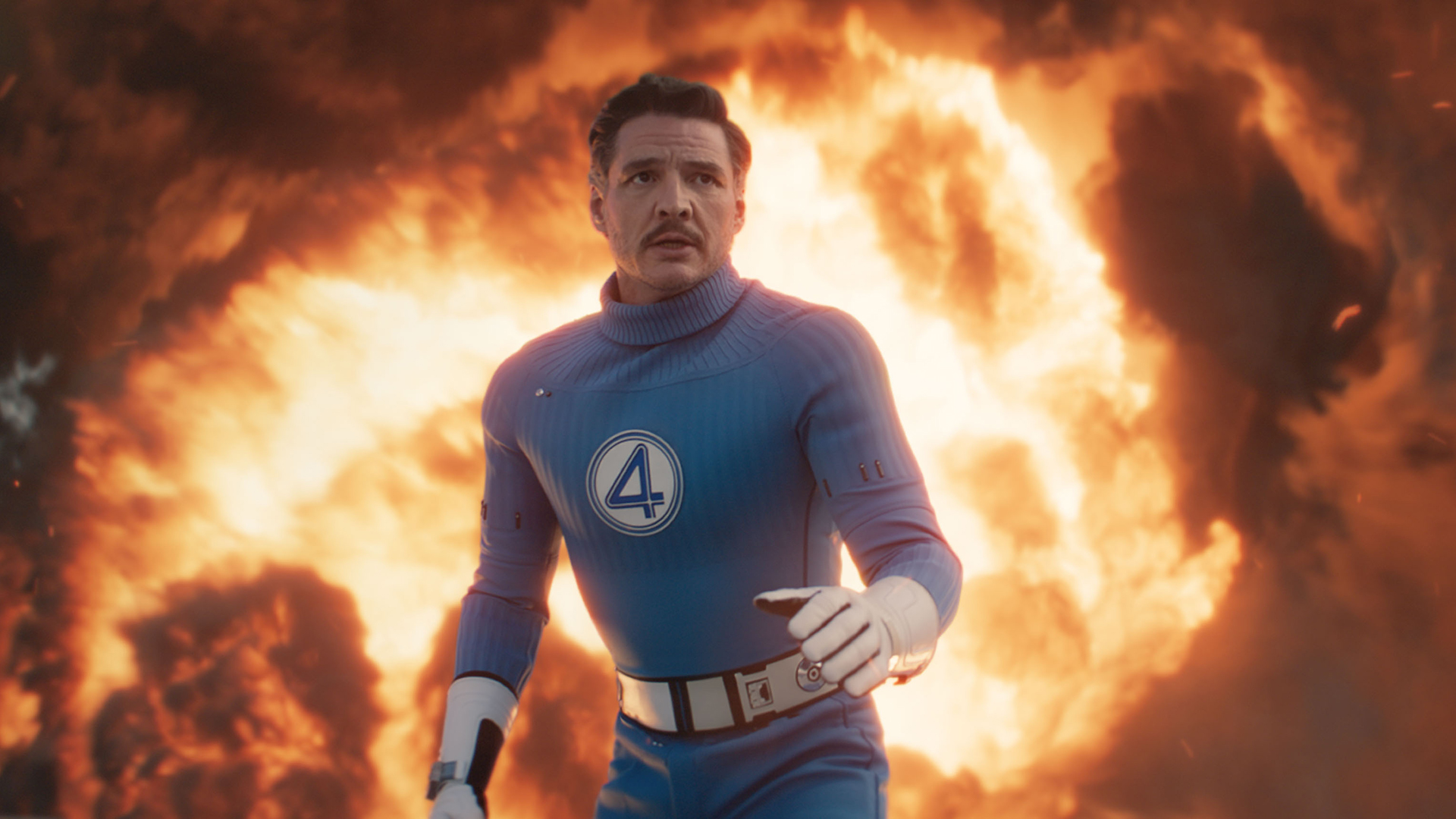 Reed Richards in an action stance with a fireball behind him in The Fantastic Four: First Steps