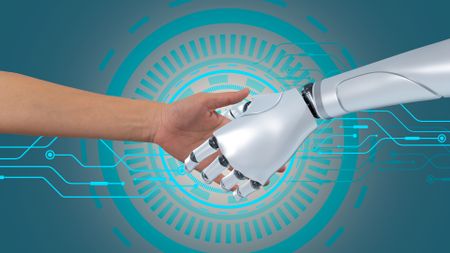 A human shakes a robot's hand in front of blue concentric circles