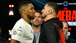 Promoter Eddie Hearn (C) stares as Albania's Kristian Prenga (R) and Britain's Anthony Joshua (L) pose at a press conference in London on June 1, 2026, ahead of their fight in Saudi Arabia in July