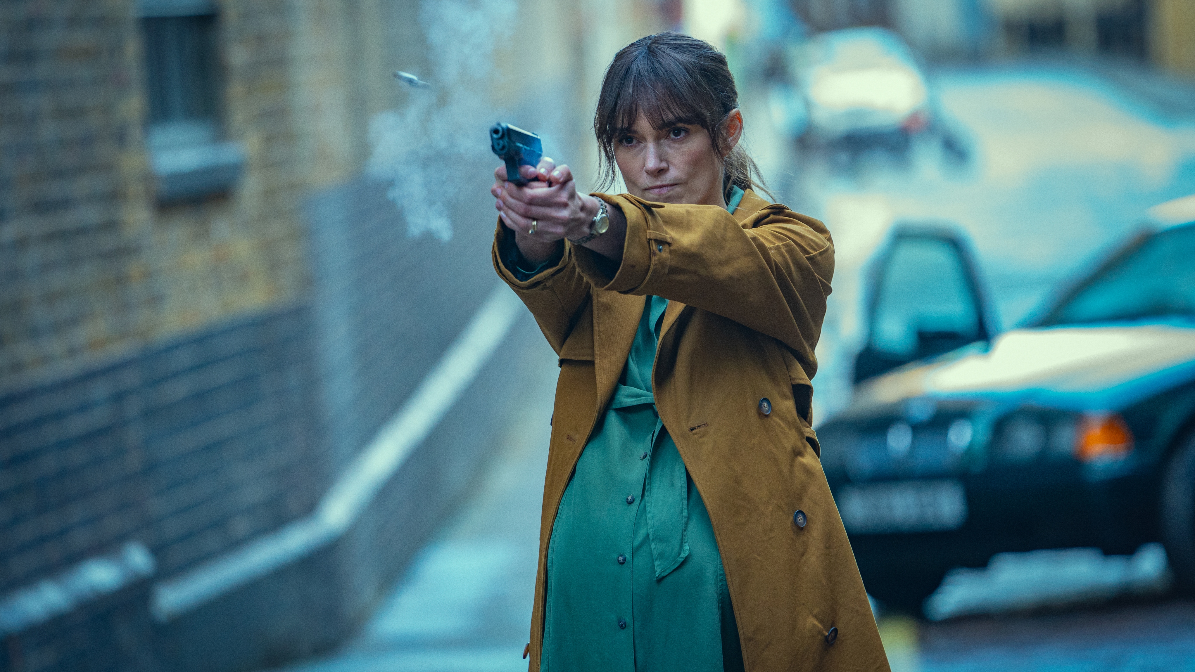 Keira Knightley as a pregnant Helen shooting a gun in Black Doves on Netflix.