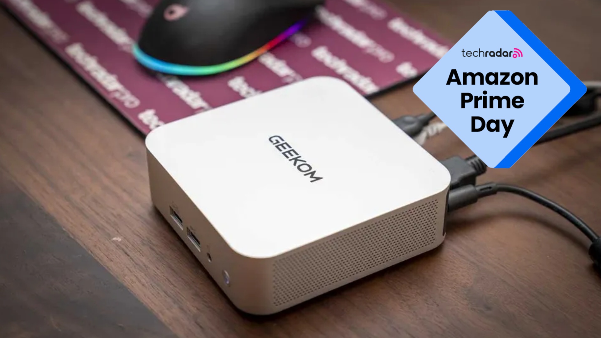 The Geekom A5 Pro mini PC on a desk next to a TechRadar Pro mouse mat, with a blue diamond TechRadar badge in the upper right reading 'Amazon Prime Day'
