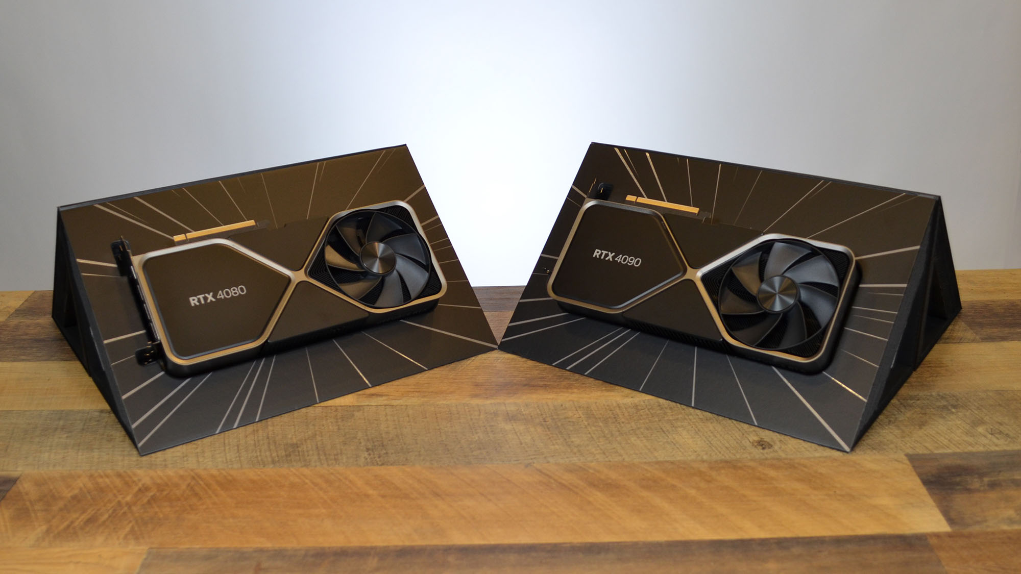 An Nvidia GeForce RTX 4080 on a wooden desk in front of a white panel