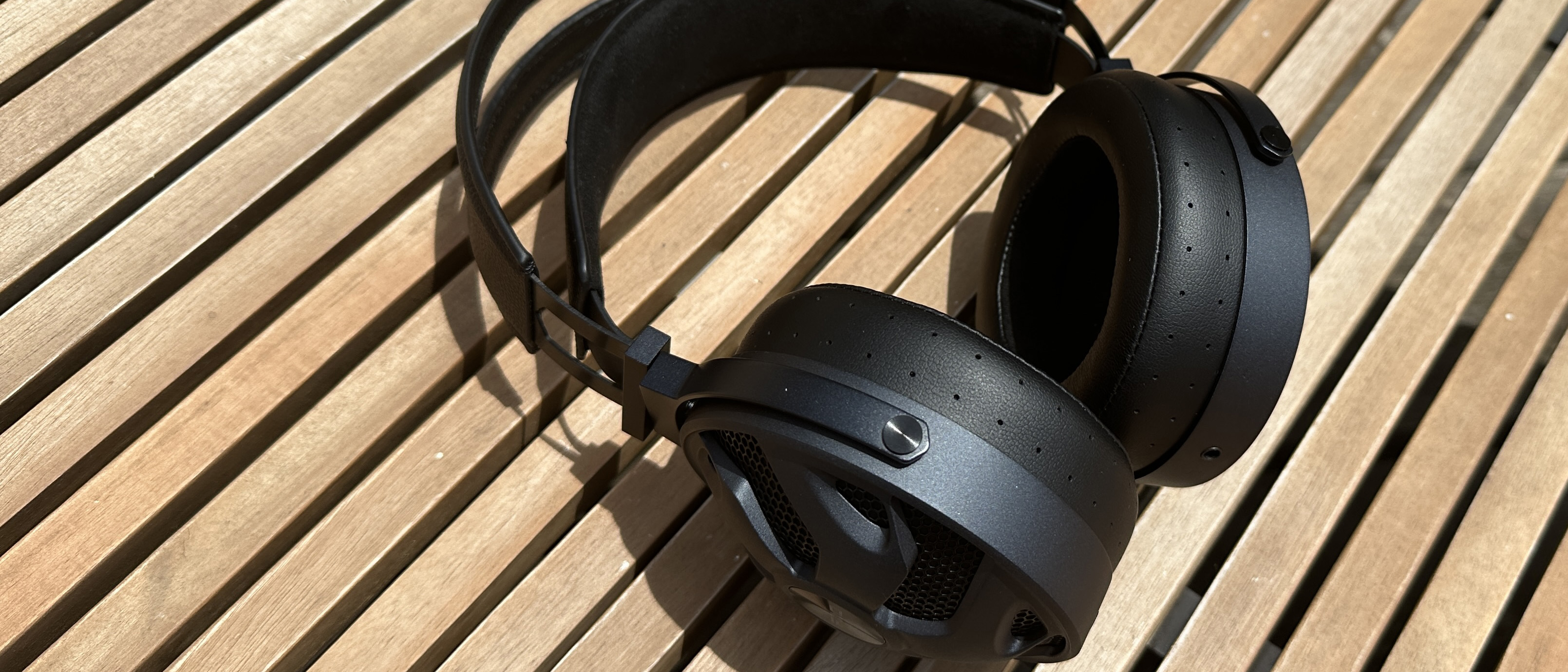 The FiiO FT3 over-ear headphones in black on a wooden surface.