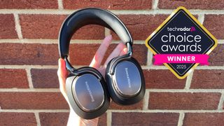 Bowers & Wilkins Px8 S2 headphones held in a woman's hands, with a logo saying TechRadar Choice Awards Winner 2025