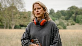 Nicola Walker holds a shooting gun in a field