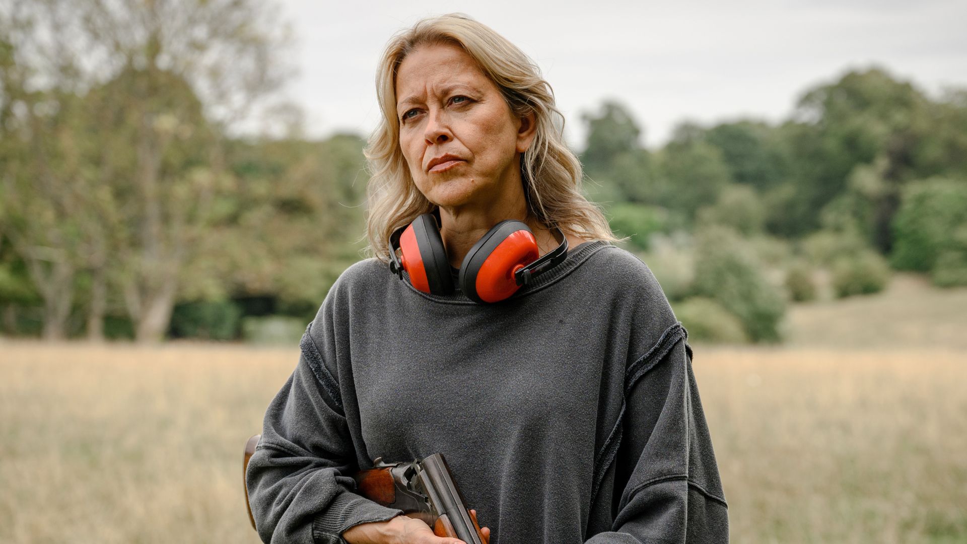 Nicola Walker holds a shooting gun in a field